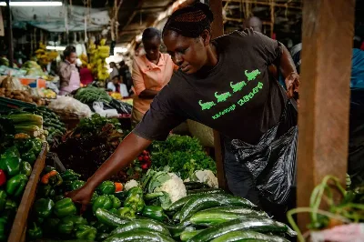A trader and fresh vegetables at a Kenyan market